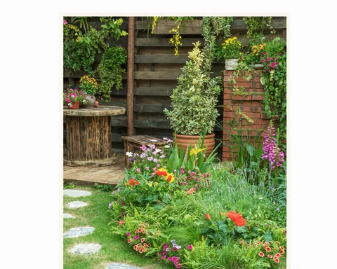 Gartenidylle mit Blumenrabatte und Sitzplatz