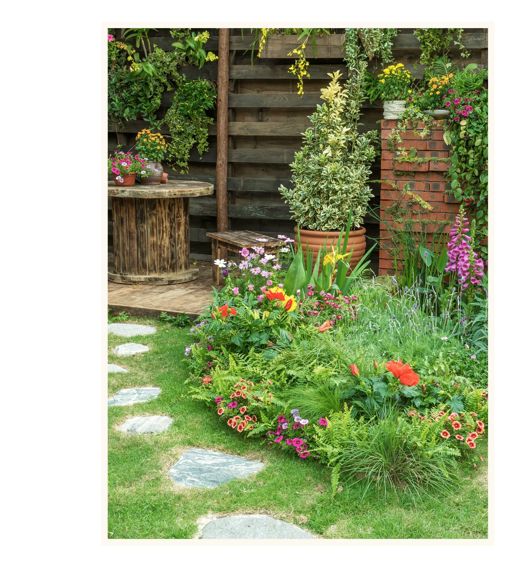 Naturnah gestalteter Garten mit Sitzplatz und Blumenrabatten
